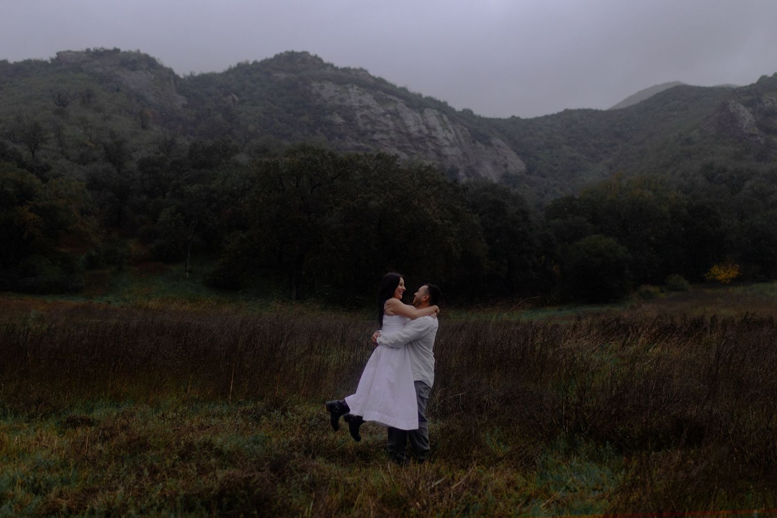 Monica and Eduardo embracing in a misty valley